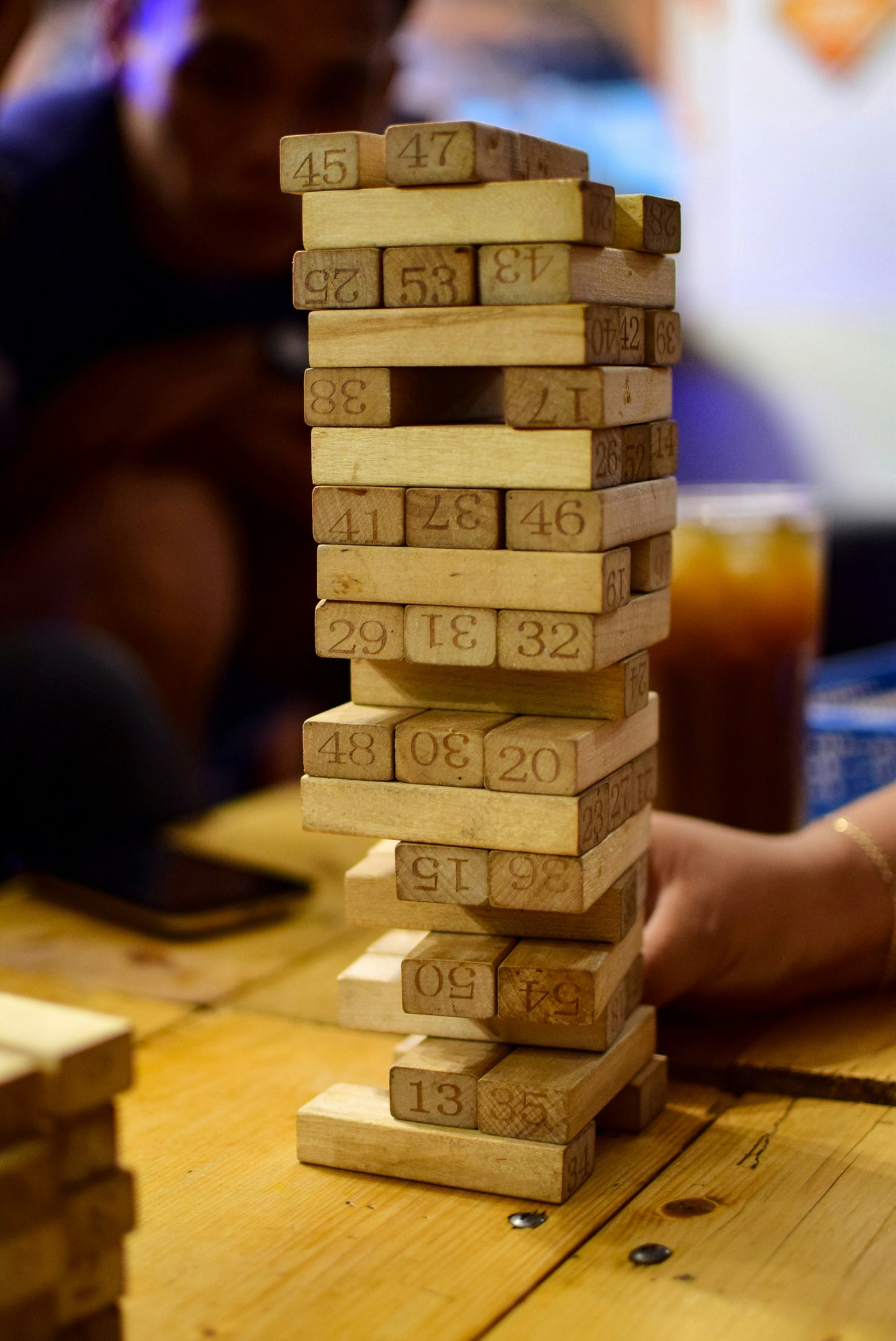 A macro close-up shot of 6–8 stacked wooden blocks showing clearly stamped/engraved numbers on the smooth, sanded hardwood surface. Highlights the quality of the number printing, the grain of the natural wood, and the splinter-free smooth edge finish. Builds trust in material quality and educational function.